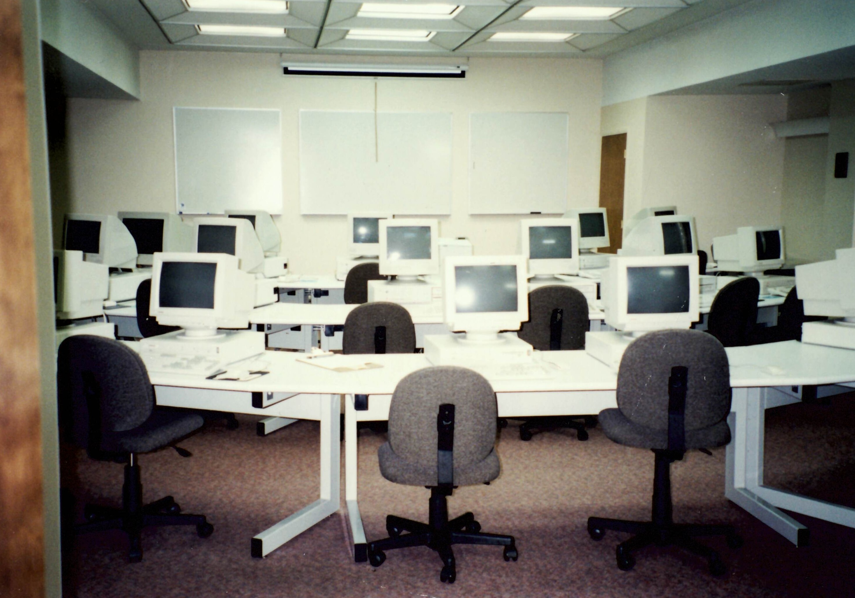 Chairs and tables filled with computers from the late 1990s.